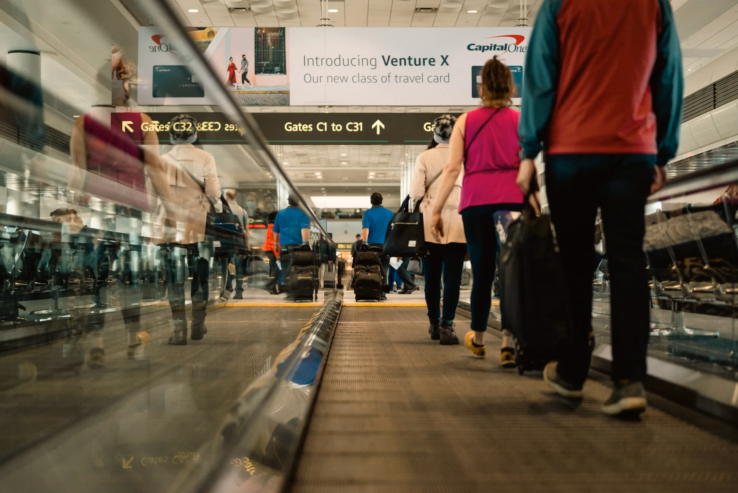Passengers on an airport moving walkway heading to gates while checking Dubai airport cancellations today