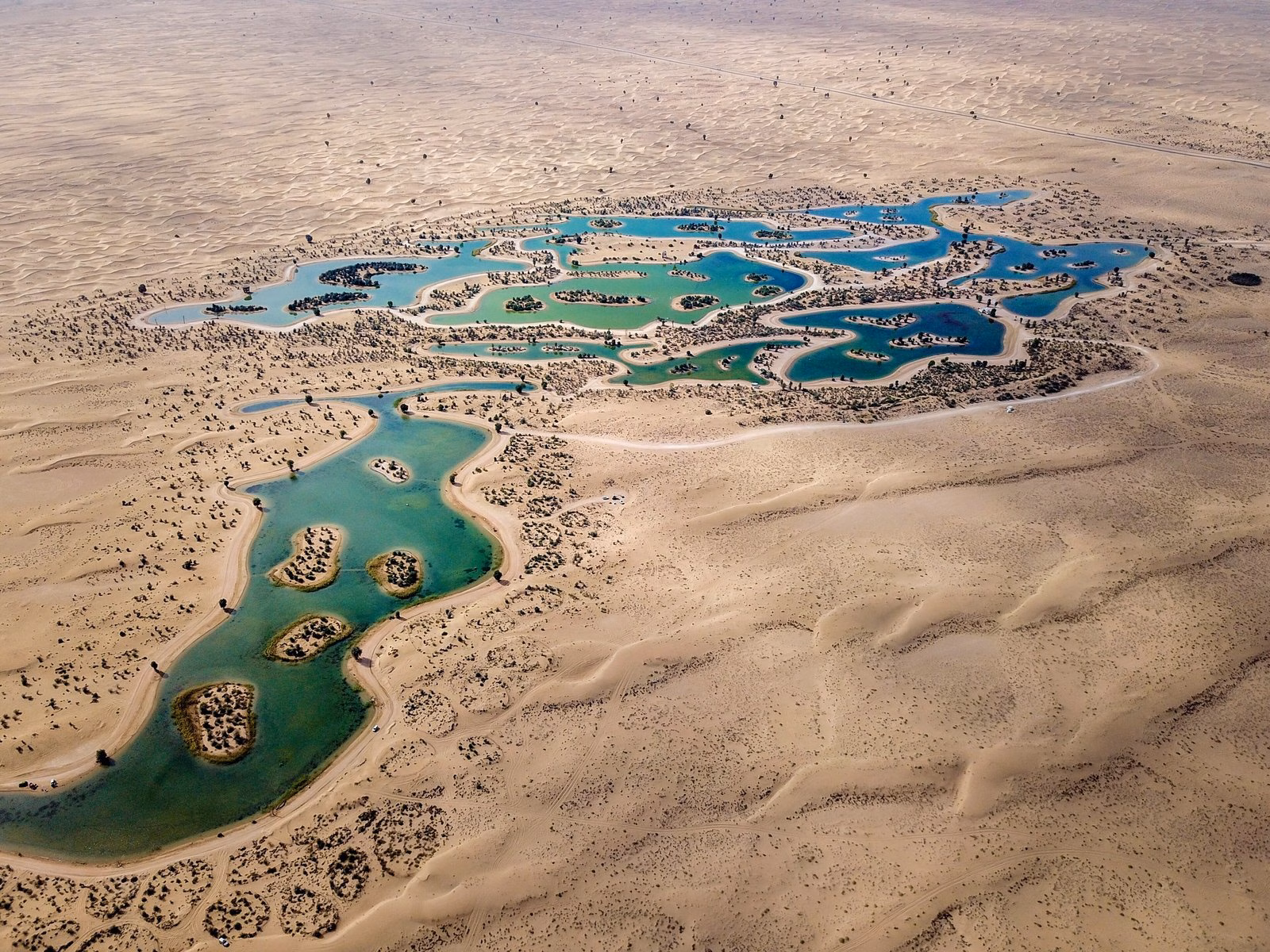 Aerial view of the man-made Al Qudra Lakes surrounded by sand in the Al Marmoum Conservation Reserve, Dubai