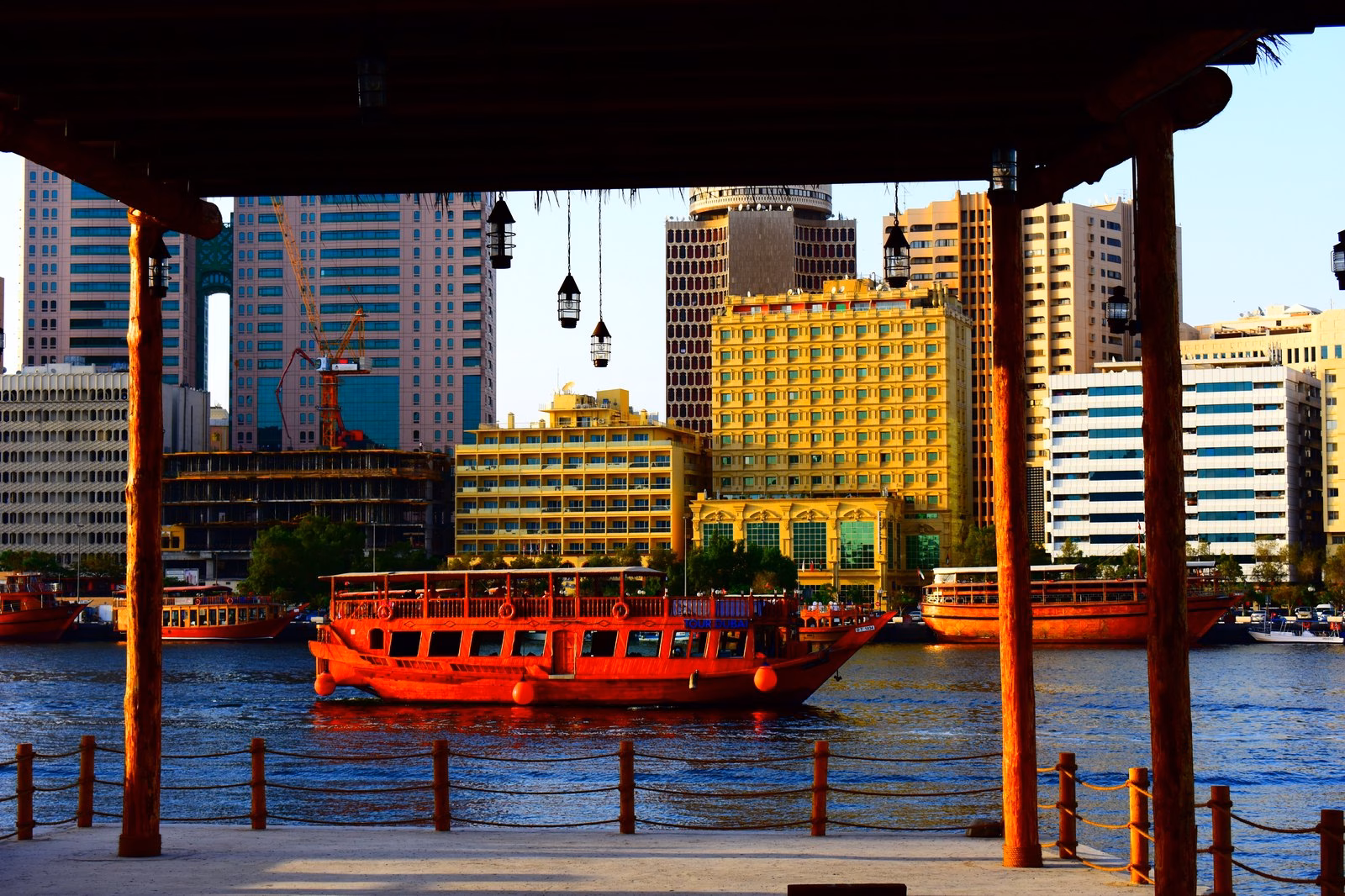 A red dhow moored on Dubai Creek with the Deira skyline behind it, in the city that hosts the Arab Hope Makers awards