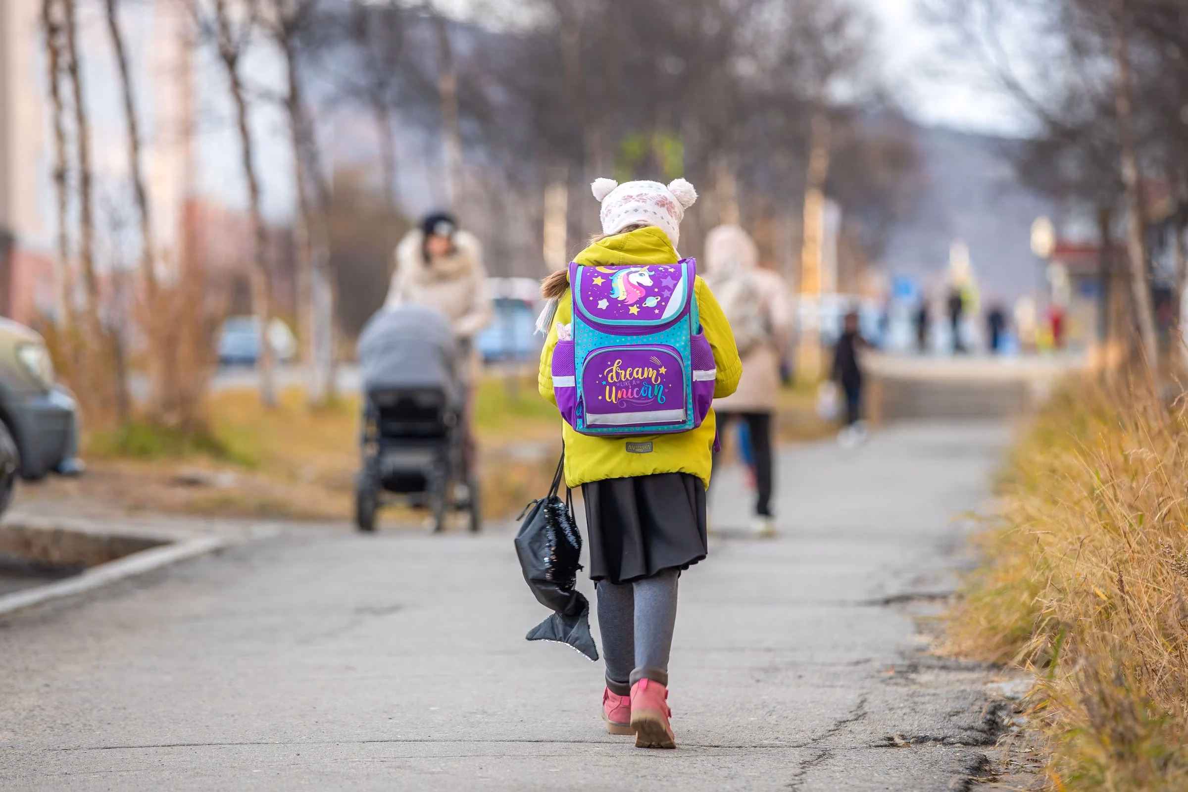 Child walking to school with a colourful backpack, a reminder of school-run photo etiquette for Dubai parents