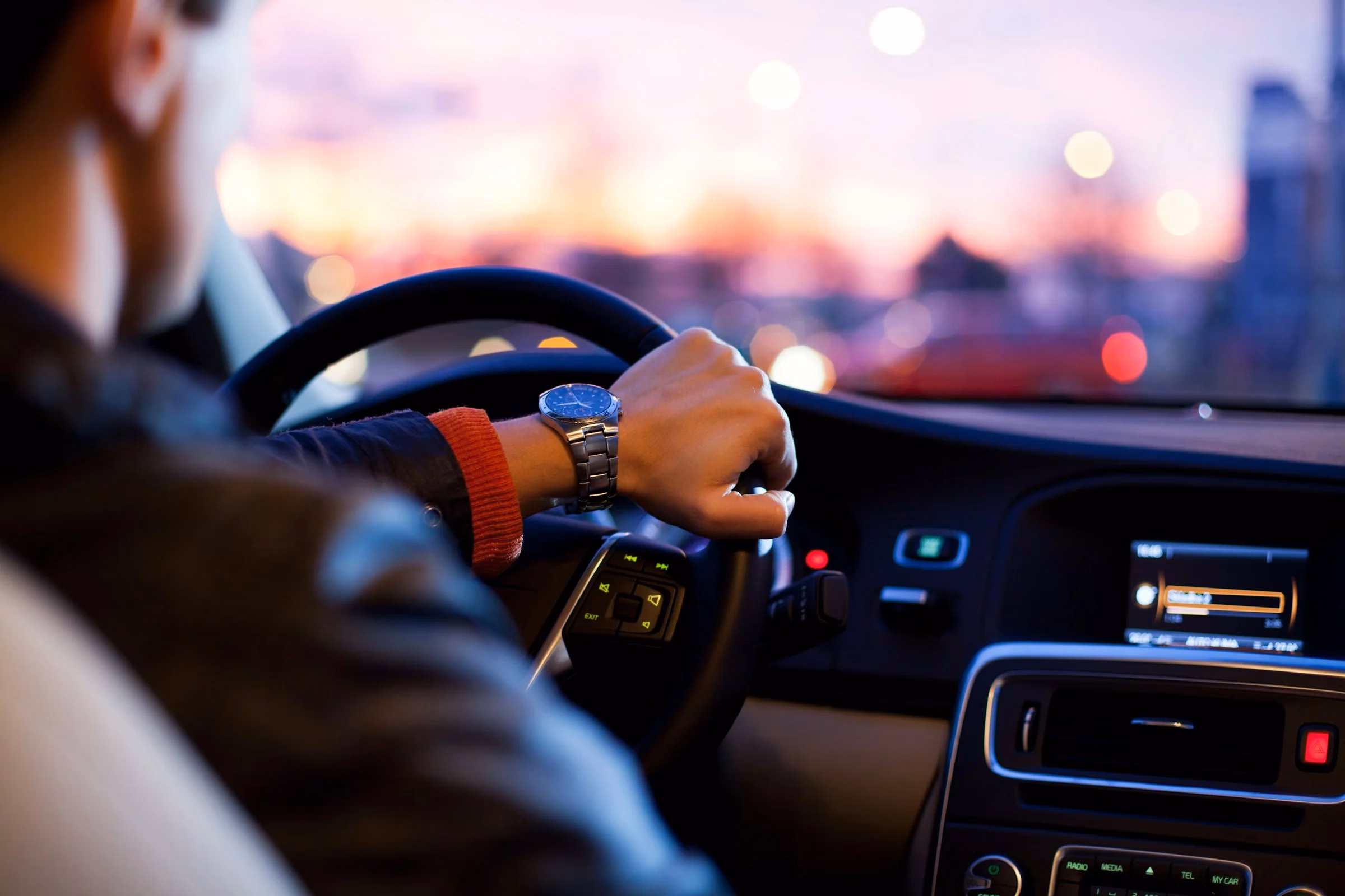 Driver at the wheel during early morning city travel, planning around Dubai cycling race traffic delays