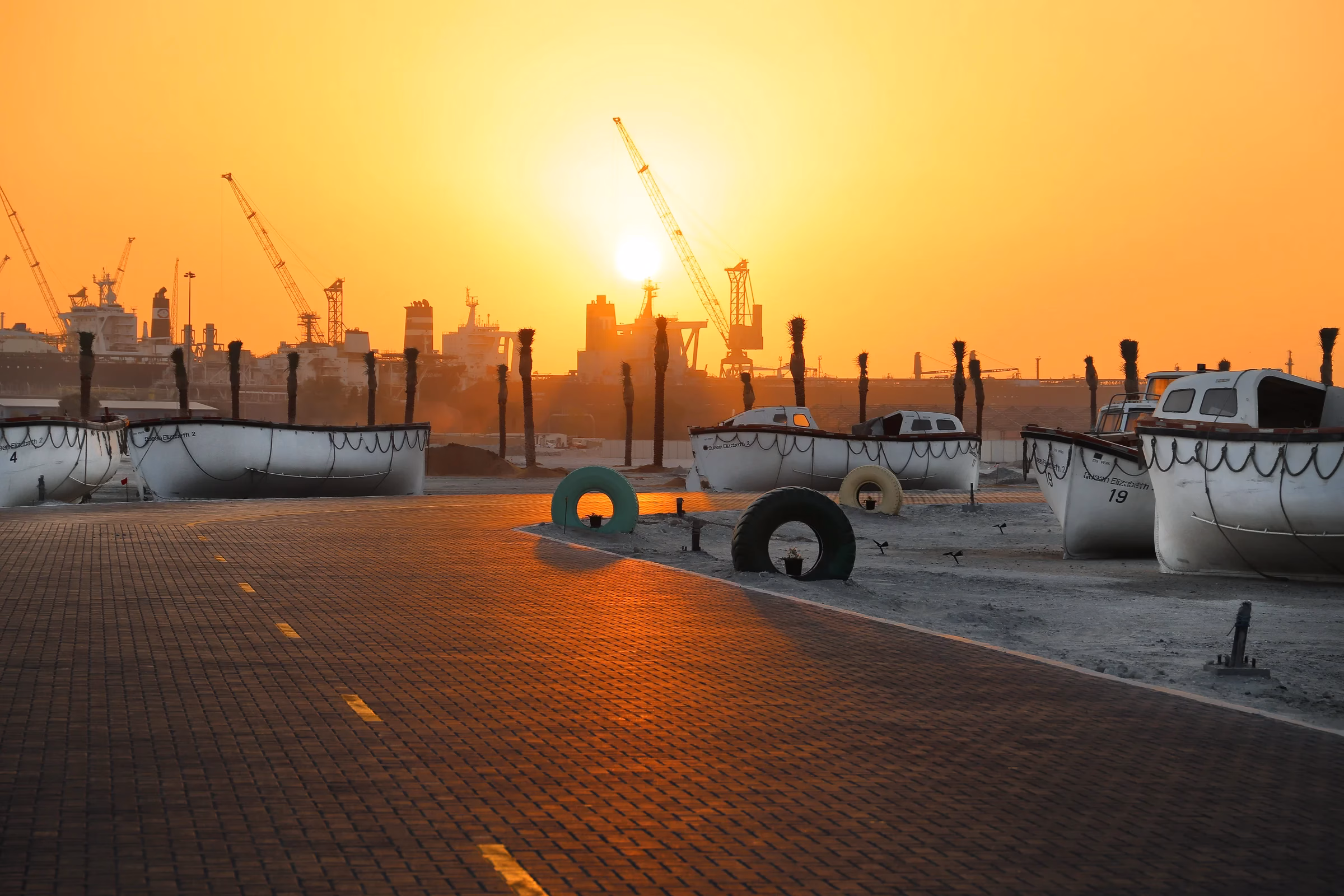 Sunset over the quay at Port Rashid, with the QE2's old lifeboats lined up near Dubai Maritime City