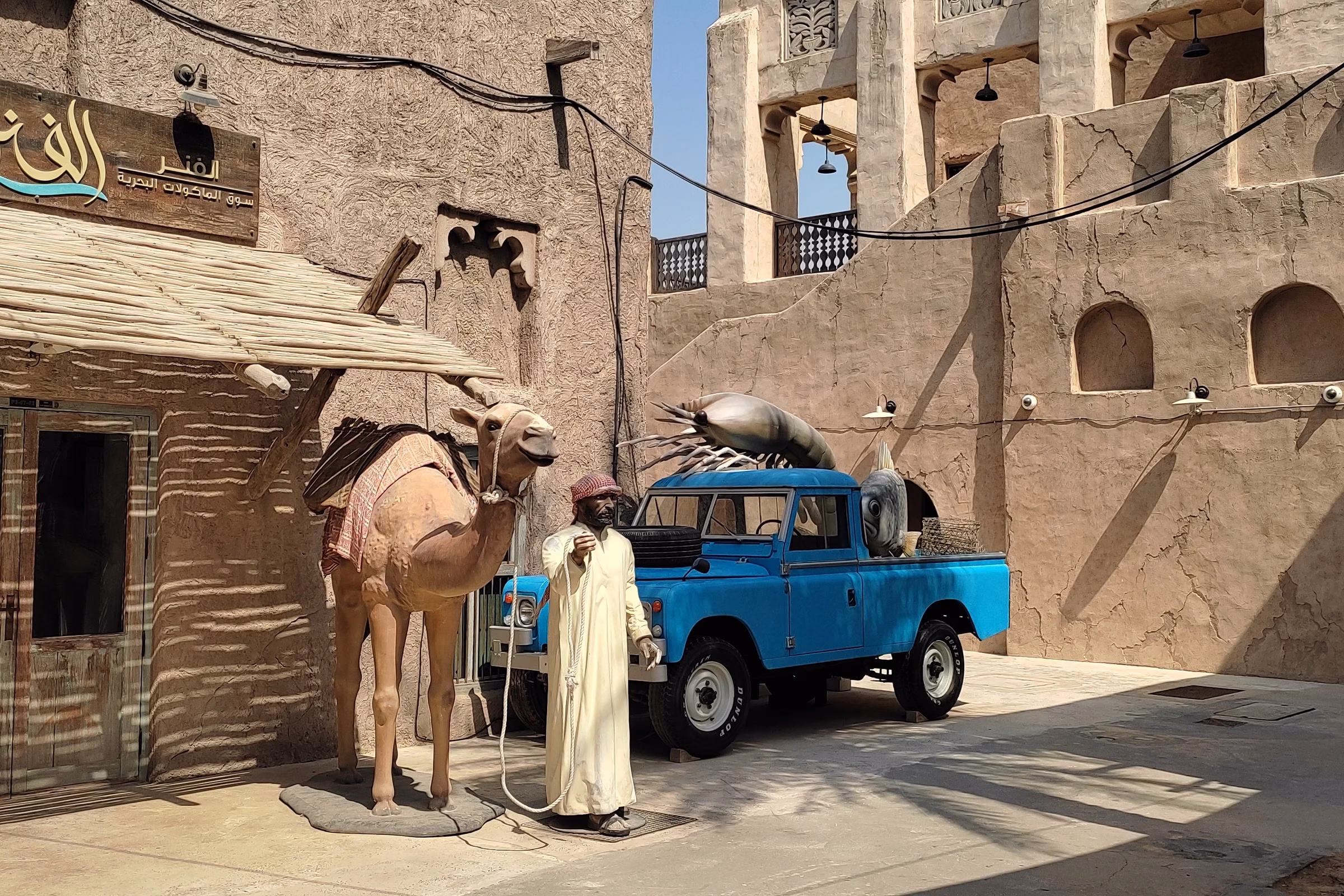 Al Fanar restaurant at Al Seef in Dubai with a vintage blue Land Rover and camel figure outside, a heritage-style eatery that diners review online