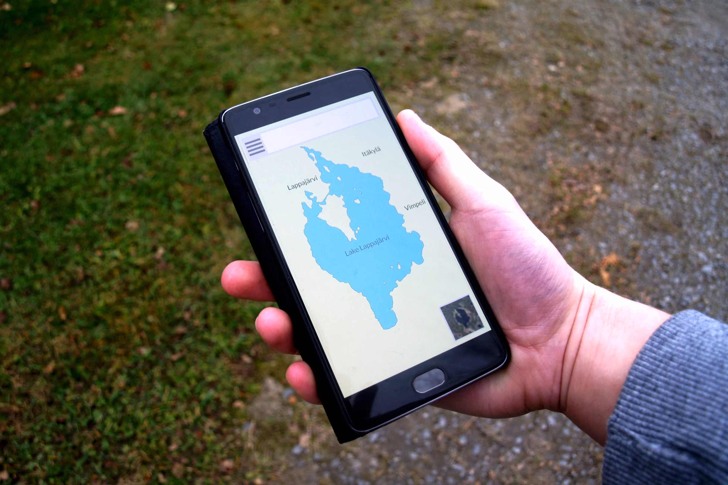 Hand holding a smartphone showing a map app outdoors, illustrating how visitors find and rate places through Dubai online reviews