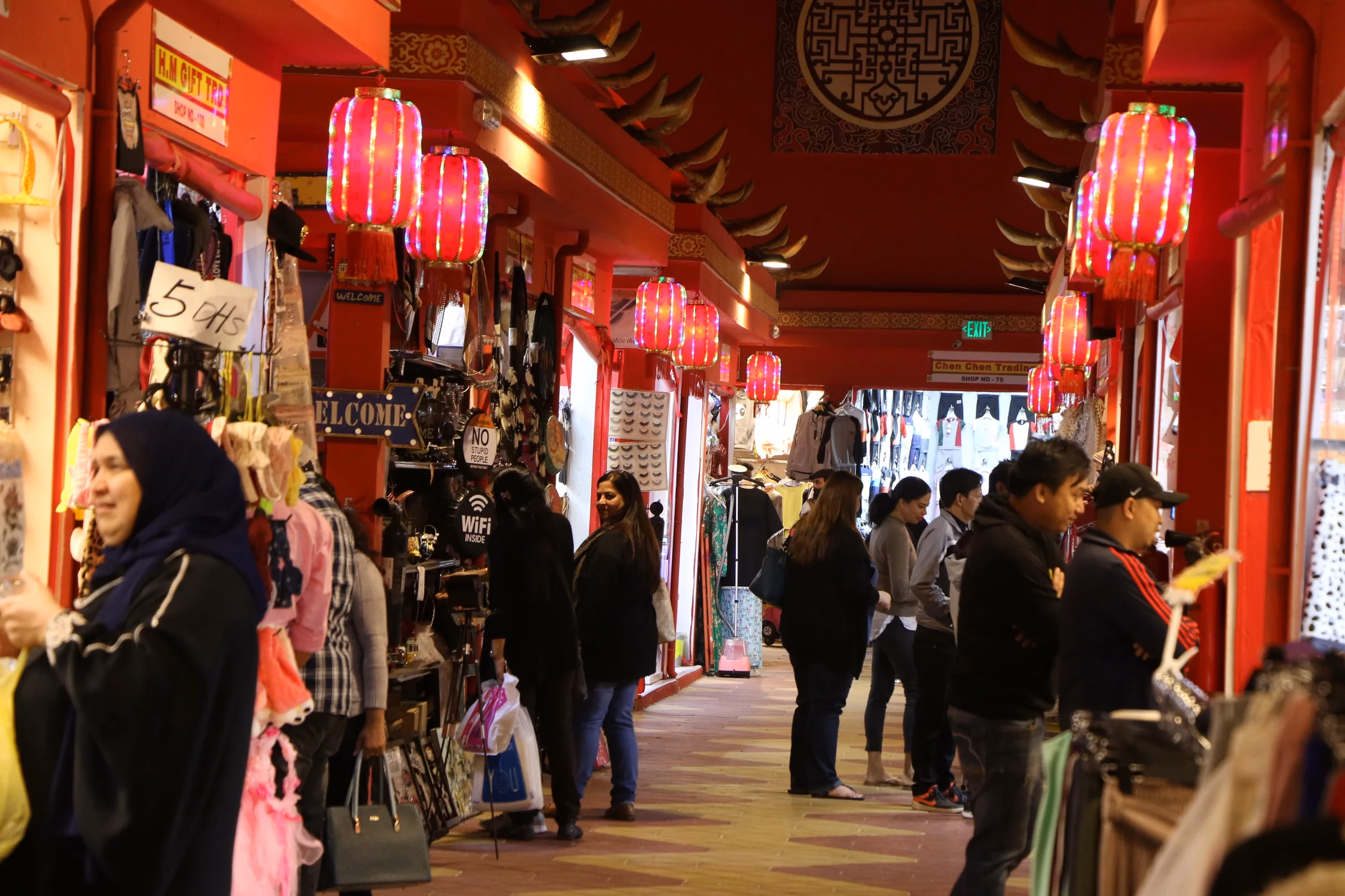 Visitors browsing lantern-lined shopfronts inside a pavilion at Global Village Dubai, one of more than 3,500 shops this season