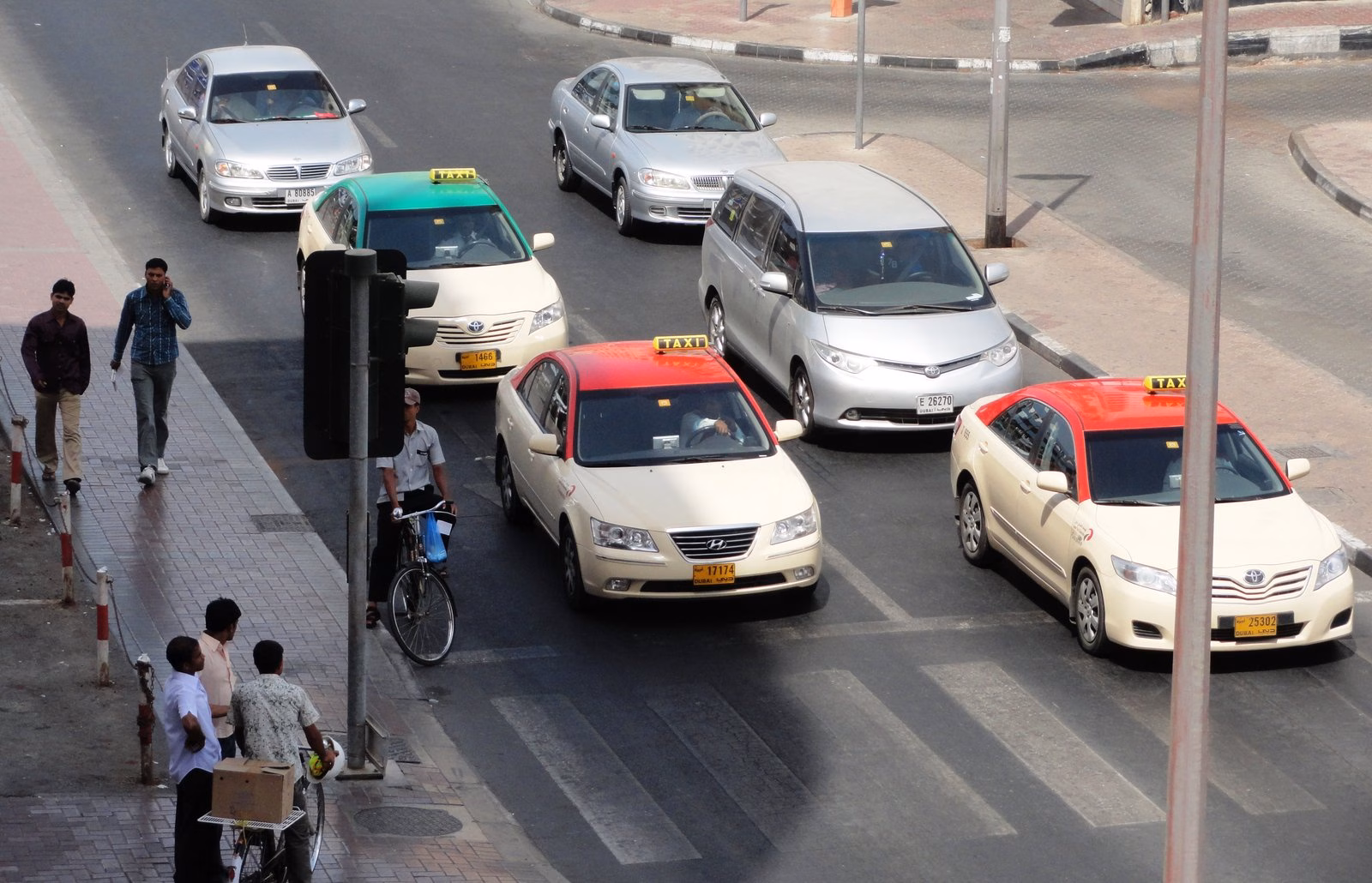 Red-roofed and cream Dubai taxis waiting at a junction in Bur Dubai, part of the fleet that includes wheelchair-accessible vehicles