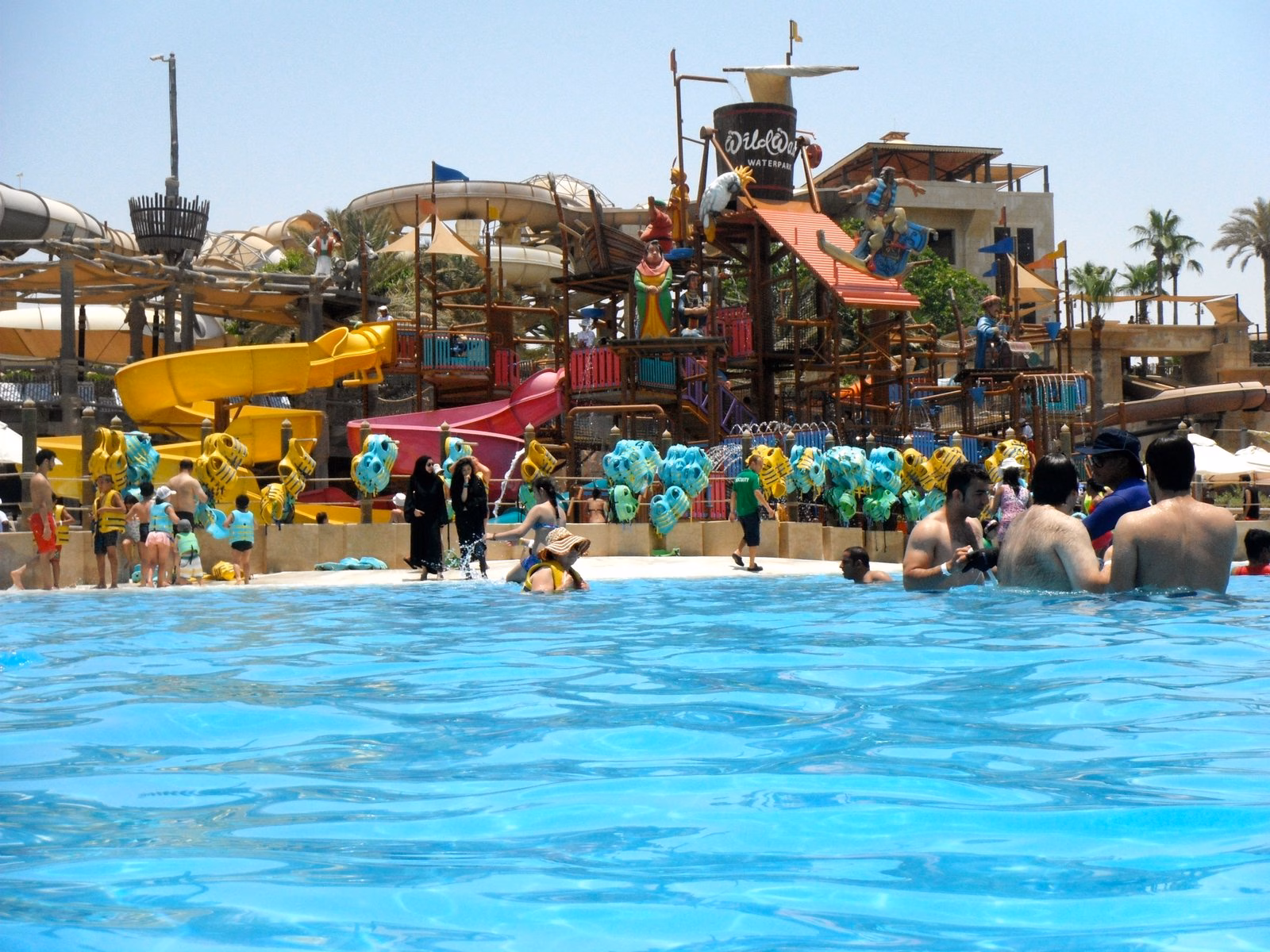 Children playing in the shallow pool beside the colourful Juha’s Dhow and Lagoon play structure at Wild Wadi Waterpark