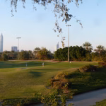 Fairways and palm trees on a golf course in Emirates Hills, Dubai, with Dubai Marina towers on the skyline ahead of the Dubai Desert Classic 2027