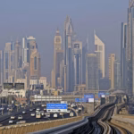 Dubai skyline and an elevated Dubai Metro track seen from a train, the network that Dubai driverless pods are designed to feed