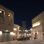 Lantern-lit café terraces between restored sand-coloured buildings at Al Seef in Dubai at night, the kind of local businesses Dubai online reviews are written about